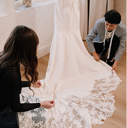 Close up of custom tailored shoulder straps and delicate fabric on a bridal gown