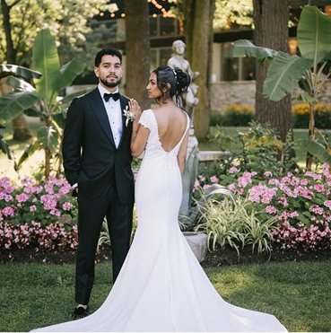 Bride and groom walking together down a beautiful outdoor garden path