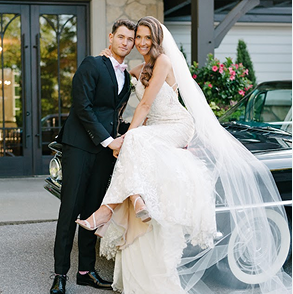 Bride and groom walking together outdoors holding hands