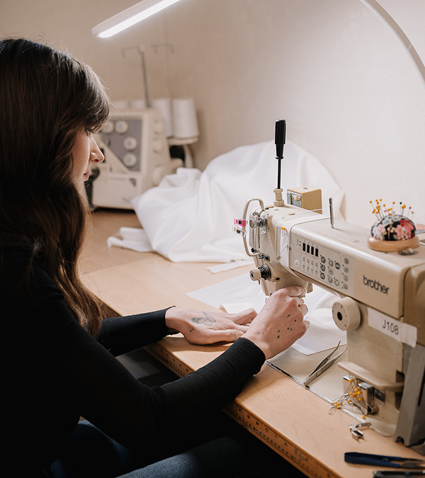 Tailor using a sewing machine for wedding dress alterations in Toronto